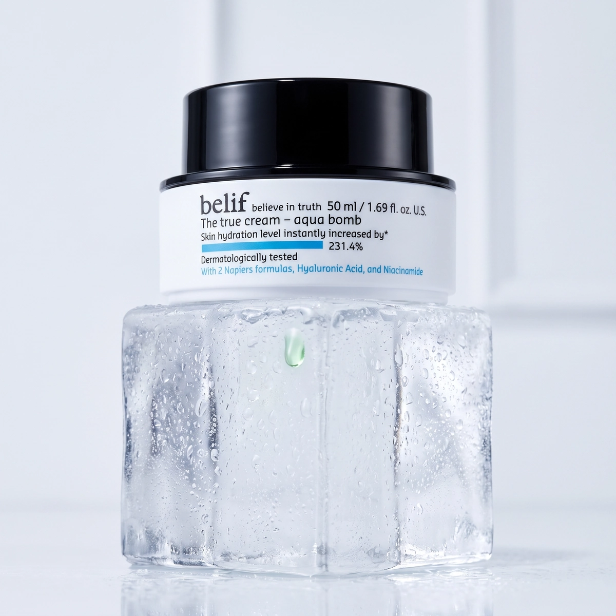 Belif The True Cream Aqua Bomb jar on a frosted ice cube, with a black lid and a cool wall