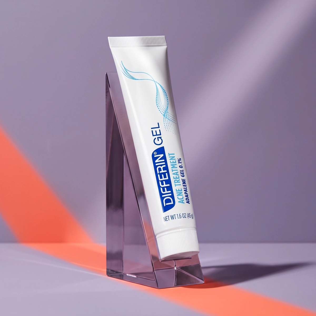 Differin Adapalene Gel tube on a lilac acrylic wedge, with a white cap and a coral light beam