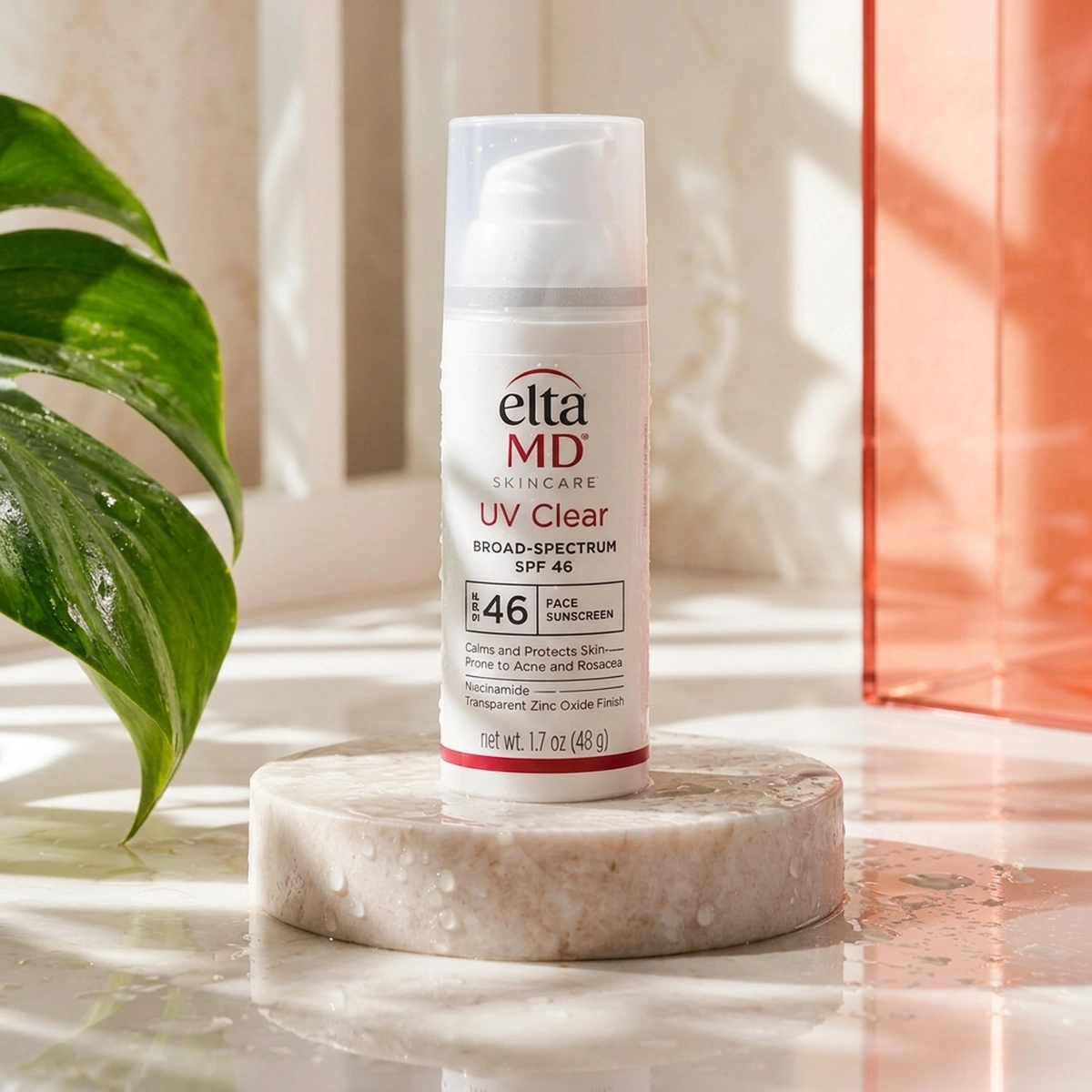 EltaMD UV Clear SPF 46 pump on a dewy botanical vanity with Eden leaf and Coral glass